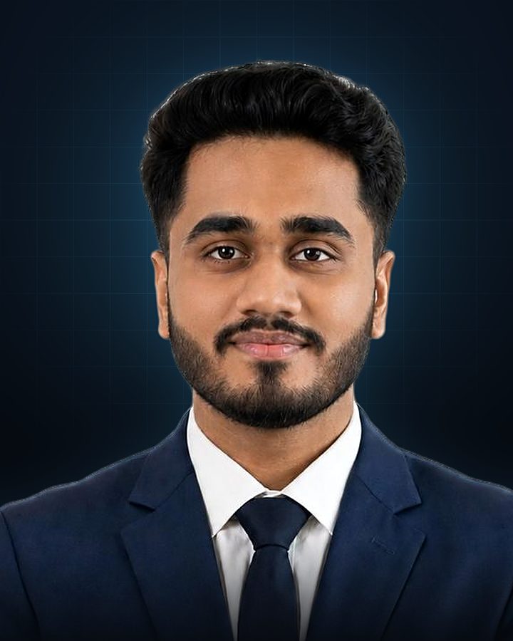 Portrait of Saurabh Sagar Shinde in a navy suit and tie, arms folded, smiling slightly.